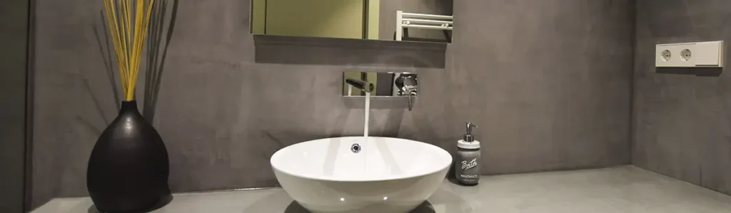 Modern Barcelona bathroom with vessel sink and grey walls Modern bathroom in Barcelona with round vessel sink, grey microcement walls and minimalist countertop decor