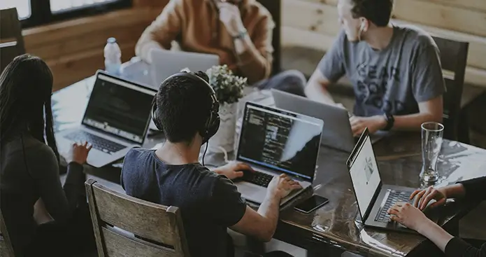 Contact Barcelona Renovation Experts team working together in the office with laptops during a project meeting - Revive Quality Team