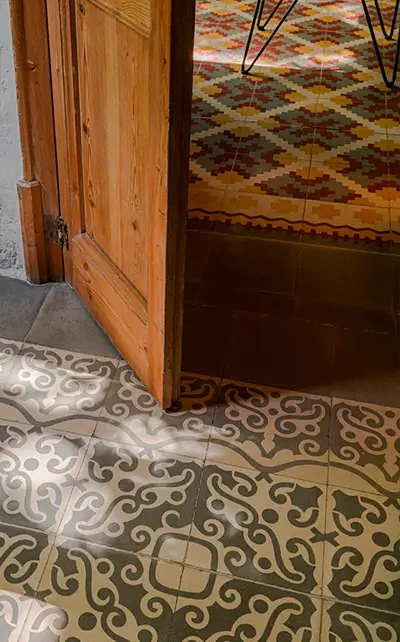 Decorative patterned floor tiles in a Barcelona apartment Flooring Barcelona ceramic tiles with traditional patterned designs at a doorway between rooms - by Revive Quality