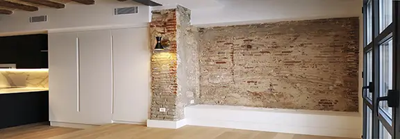 Open-plan Gràcia apartment with exposed brick feature wall Renovated Gràcia apartment with open-plan layout, exposed brick wall and modern kitchen area - by Revive Quality