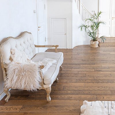 Bright Barcelona living space with premium hardwood flooring and elegant white sofa installed by Revive Quality