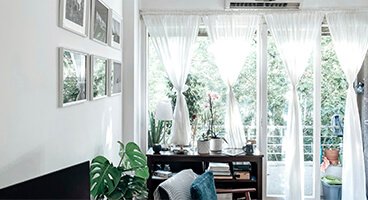 Bright Barcelona living room with large windows, greenery views and styled interior documented during on-site renovation assessment