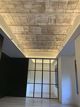 Renovated Barcelona living space with exposed brick ceiling Renovated Barcelona apartment with exposed brick ceiling, indirect lighting and black-framed glass partition