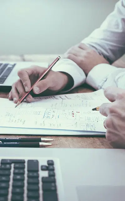 Planning renovation paperwork and permit applications in Barcelona Renovation Permits Barcelona planning meeting with architects reviewing paperwork, costs and license requirements at a desk