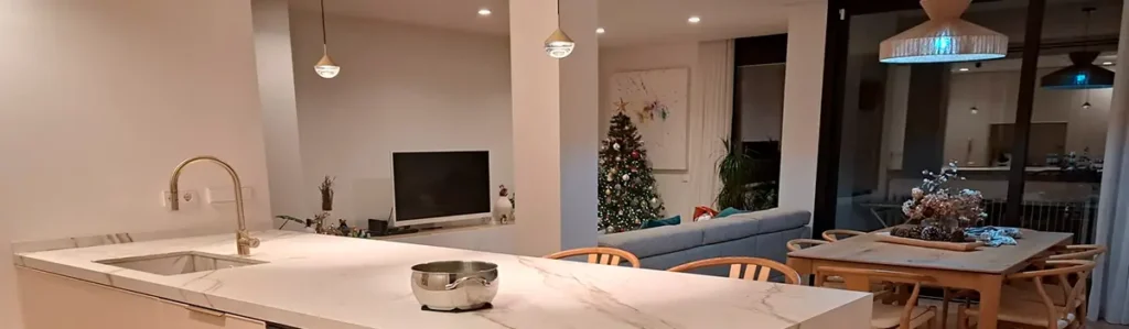 Open-plan Eixample apartment with central marble kitchen island Renovation Project Barcelona showcasing an Eixample open-plan apartment with marble kitchen island, dining table, living area and Christmas tree